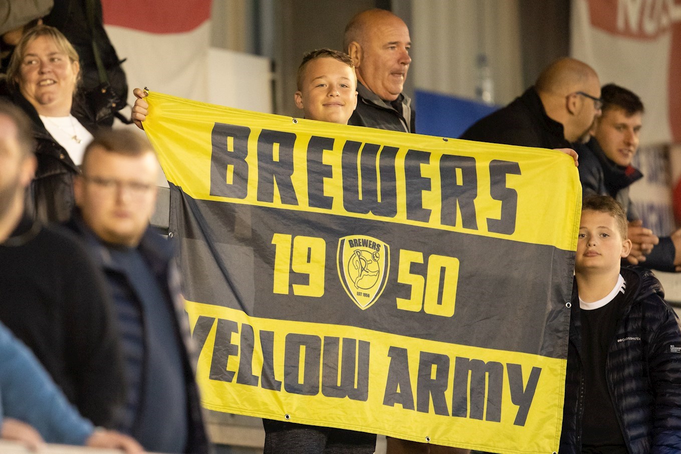 A YOUNG Burton Albion fan proudly shows his Brewers flag to the camera in our first game back in front of fans - a pre-season friendly at Nuneaton Borough